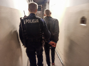 Policjant prowadzi zatrzymanego