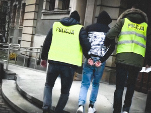 policjanci prowadza zatrzymanego