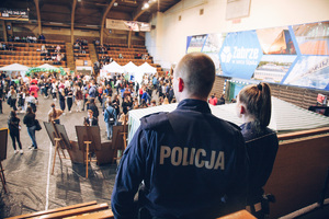 Policjanci zabrzańskiej komendy na targach edukacyjnych oglądają stoiska wystawowe z trybuny