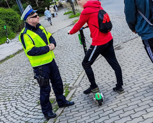 Policjant kontroluje kierującego hulajnogą