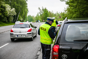 Na zdjęciu policjant ruchu drogowego podczas prowadzenia kontroli na  drodze