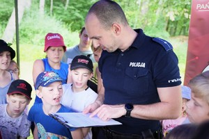 Zdjęcia kolorowe: Umundurowani policjanci przeprowadzający zajęcia profilaktyczne dla dzieci i młodzieży na terenie Kąpieliska Leśnego w Zabrzu.