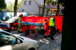 Policjanci i inne służby ratunkowe na miejscu zdarzenia drogowego.