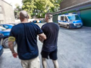 Zatrzymany mężczyzna prowadzony przez policjanta