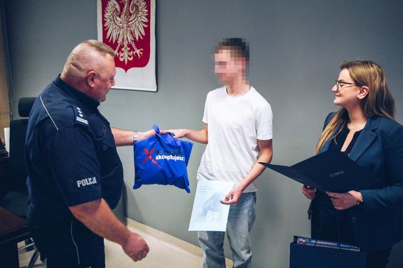 Pani Prezydent Zabrza i Komendant Miejskie Policji w Zabrzu wręczają listy gratulacyjne nastolatkowi.
