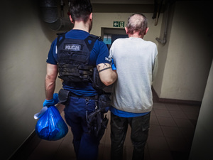 Policjant prowadzi zatrzymanego
