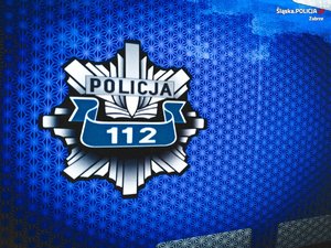 Zdjęcie kolorowe przedstawiające policyjne logo z napisem &quot;Policja 112&quot;.
