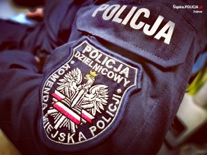 Zdjęcie kolorowe przedstawiające naszywkę na mundurze z napisem &quot;Policja dzielnicowy Komenda Miejska Policji&quot;.