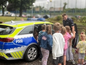 Zdjęcia kolorowe przedstawiające umundurowanych policjantów podczas przeprowadzania zajęć profilaktycznych dla dzieci podczas półkolonii.