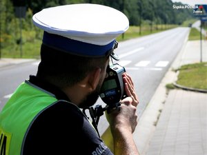 Policjant mierzy prędkość na drodze.