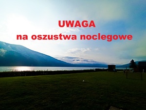 Widok na  góry z napisem uwaga na  oszustwa noclegowe