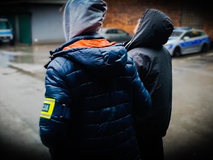 Policjant prowadzi zatrzymanego