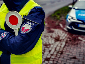 Policjant z tarczą do zatrzymywania pojazdów.