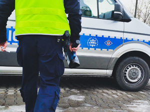 na zdjęciu policjant niesie miernik prędkości