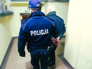 na zdjęciu policjant powadzi zatrzymanego