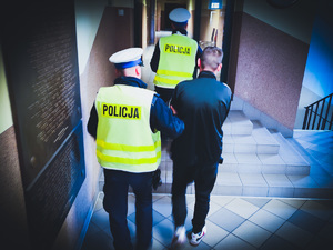Policjant ruchu drogowego prowadzi zatrzymanego