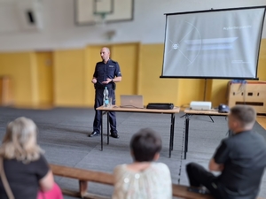 Policyjny profilaktyk prowadzący prelekcję edukacyjną dla rodziców.