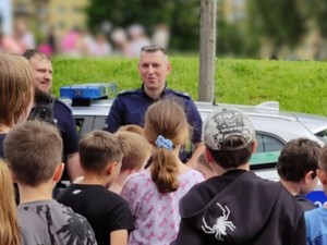 Umundurowani policjanci przeprowadzający prelekcję dla uczniów.