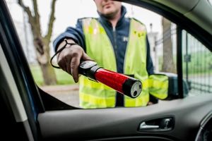 na zdjęciu policjant z alko-sensorem