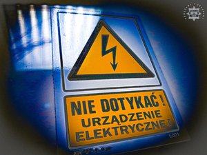 Tablica informacyjna z napisem &quot;Nie dotykać urządzenie elektryczne&quot;.