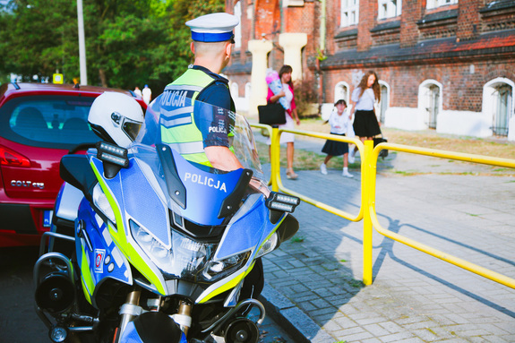 na zdjęciu policjant obok szkoły