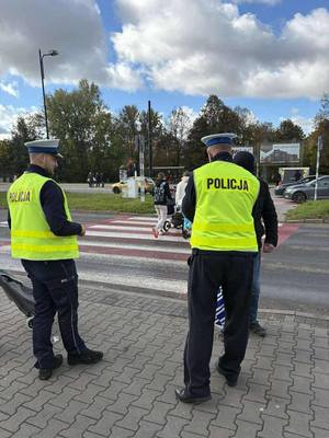 na zdjęciu policjanci podczas rozdawania odblasków