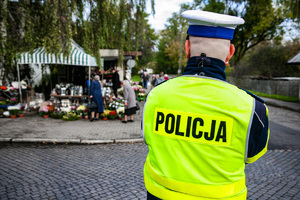 na zdjeciu policjant na  cmentarzu
