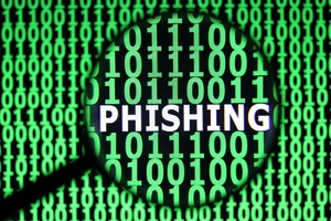 grafika przedstawiająca kod binarny pod lupa i napis phishing