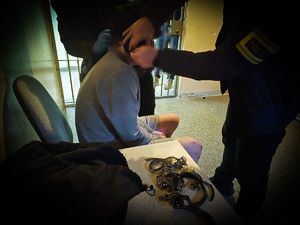 na zdjęciu policjant i zatrzymana osoba