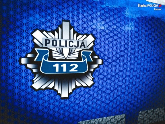Zdjęcie kolorowe przedstawiające policyjną gwiazdę z napisem "Policja 112".