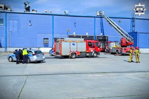 radiowóz i woź straży pożarnej przy hali