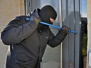 zamaskowana osoba włamuje się do budynku