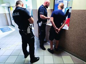 Policjanci ruchu drogowego z zatrzymanym mężczyzną