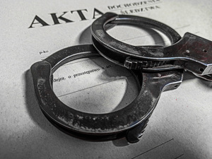 na zdjęciu akta i kajdanki