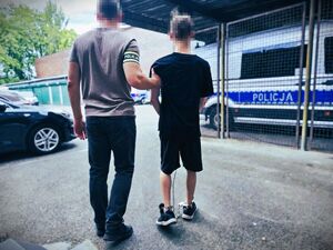 policjant prowadzi zatrzymanego