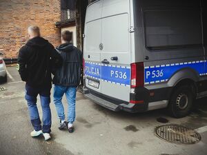 policjant prowadzi zatrzymanego